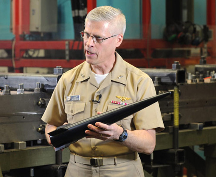 Rear Adm. Matthew Klunder, chief of naval research, shows the  Hypervelocity Projectile (HVP). The next-generation projectile is designed as common, low drag, guided projectile capable of completing multiple missions for gun systems such as the Navy 5-inch, 155-mm, and future railguns. Photo: US Navy by John F. Williams.