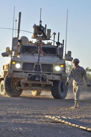 Sgt. Daniel J. Hadley, a combat engineer in the Charlie Company, Special Troops Battalion, ground guides a Mine Resistant Ambush Protected vehicle to relocate the tactical operations center during the pilot week of Network Integration Evaluation 13.1, which took place in October-November 2012, at Fort Bliss, Texas, and White Sands Missile Range, N.M. (Photo credit: Sgt. Ida Irby, 24th Press Camp Headquarters)