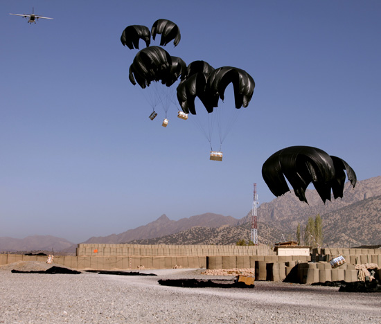 Bundles of bottled water attached to parachutes fall from an aircraft during an aerial resupply on Combat Outpost Herrera, Paktiya province, Afghanistan. Photo:  Staff Sgt. Andrew Smith