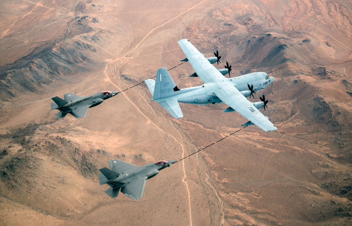 An F-35B (left) and F-35C (right) Lightning II fighters flying from Edwards AFB refuel from a USMC KC-130J tanker over the Mojave desert, Ca. 