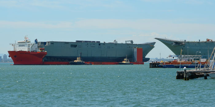 The new hull of Nuship Adelaide carried by the Blue marlin passes by Nuship Canberra nearing completion at BAE Melbourne. The Adelaide was ferried from Spain to Australia. Photo: Ross Johnson