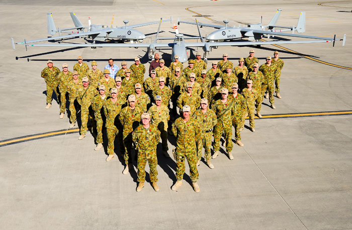 In November 2013 the Royal Australian Air Force Air Component completed 20,000 combat flying hours in Afghanistan. In this photo, the unit commander Group Captain Tony McCormack stands alongside members of the Heron Remotely Piloted Aircraft Detachment (Rotation 13) that operated the mission on this milestone flight.  Each Heron detachment consists of about 30 ADF personnel based at Kandahar Airfield in Southern Afghanistan. Photo: RAAF Chris Moore