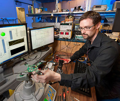 Dr. Joseph Conroy checks the vehicle operation of the ARL micro-quadrotor, a platform for testing integrated sensing and processing on size constrained robotic systems. (ARL Photo by Doug Lafon)