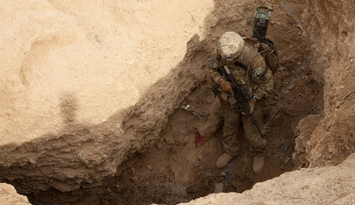 Staff Sgt. Dave Townzen, 716th Explosive Ordinance Disposal, Task Force Paladin, enters an underground tunnel in search of insurgent weapons caches. Photo: US Army Spc. Jason Nolte
