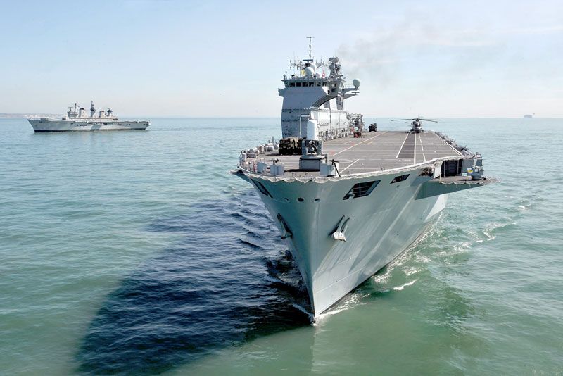 In a symbolic gesture the UK’s outgoing helicopter carrier has handed over duties to her successor. HMS Ocean (foreground) is succeeding HMS Illustrious (background). Photo: UK MOD, Crown Copyright 