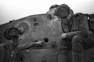 Russian tank crew inspect a turret of a German Tiger I defeated by an armor-piercing shell from the T-34's 76-mm tank gun.