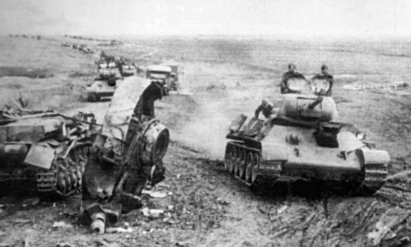 Russian T-34 column pass a destroyed German Pz-IV near Khrakov.