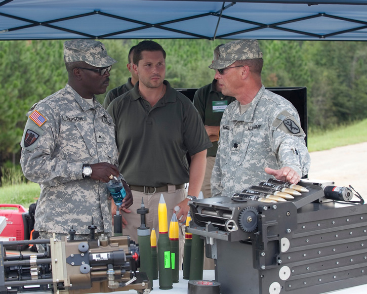Brigadier General Lester Simpson receives a briefing from Col. about the new cannon's feeding system.