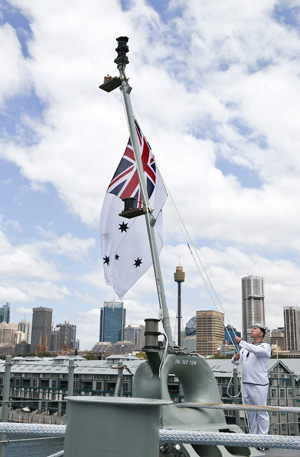 The Australian White Ensign raised onboard HMAS Canberra during the commissioning ceremony, Fleet Base East, Sydney. Photo: RAN by Helen Frank 
