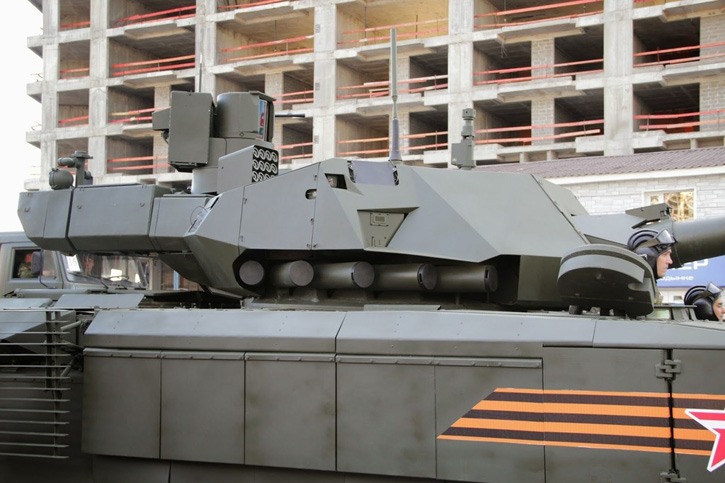The T-14 tank mounts two active protection assemblies on both sides of the turret. Covered by passive armor for ballistic protection, these modules integrate the Afghanit sensor (trapezoidal unit), five hard-kill launch tubes mounted at the turret's base, two peripheral cameras and flat (possibly covered) sensor, likely  radar coupled with the soft-kill system. Some sources indicate these sensors are derived from AESA radar technology developed and implemented on the Sukhoi T-50 stealth fighter jet. The rotatable soft-kill launcher containing 12 cartridges can be seen above, mounted on a rotating pedestal. 
