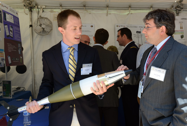 Nick Baldwin and Evan Young, researchers with the Armament Research Development and Engineering Center at Picatinny Arsenal, New Jersey, discuss the 120mm Guided Enhanced Fragmentation Mortar during the DOD Lab Day, May 14 at the Pentagon Photo: US Army by C. Todd Lopez