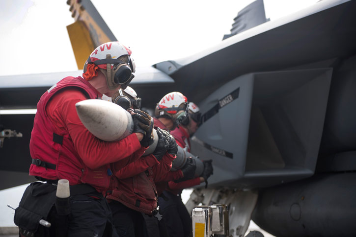 Aviation Ordnancemen assigned to Strike Fighter Squadron (VFA) 25, upload an AIM-120 AMRAAM missile to an F/A-18E Super Hornet on the flight deck of aircraft carrier USS Harry S. Truman (CVN 75). Photo: US Navy by E. T. Miller