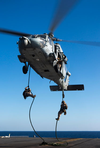 US Marines fast rope out of an SH-60 Seahawk with Amphibious Squadron 4 during fast rope training aboard the amphibious assault ship USS Kearsarge Nov. 5, 2015. U.S. Marine Corps photo by Cpl. Joshua W. Brown